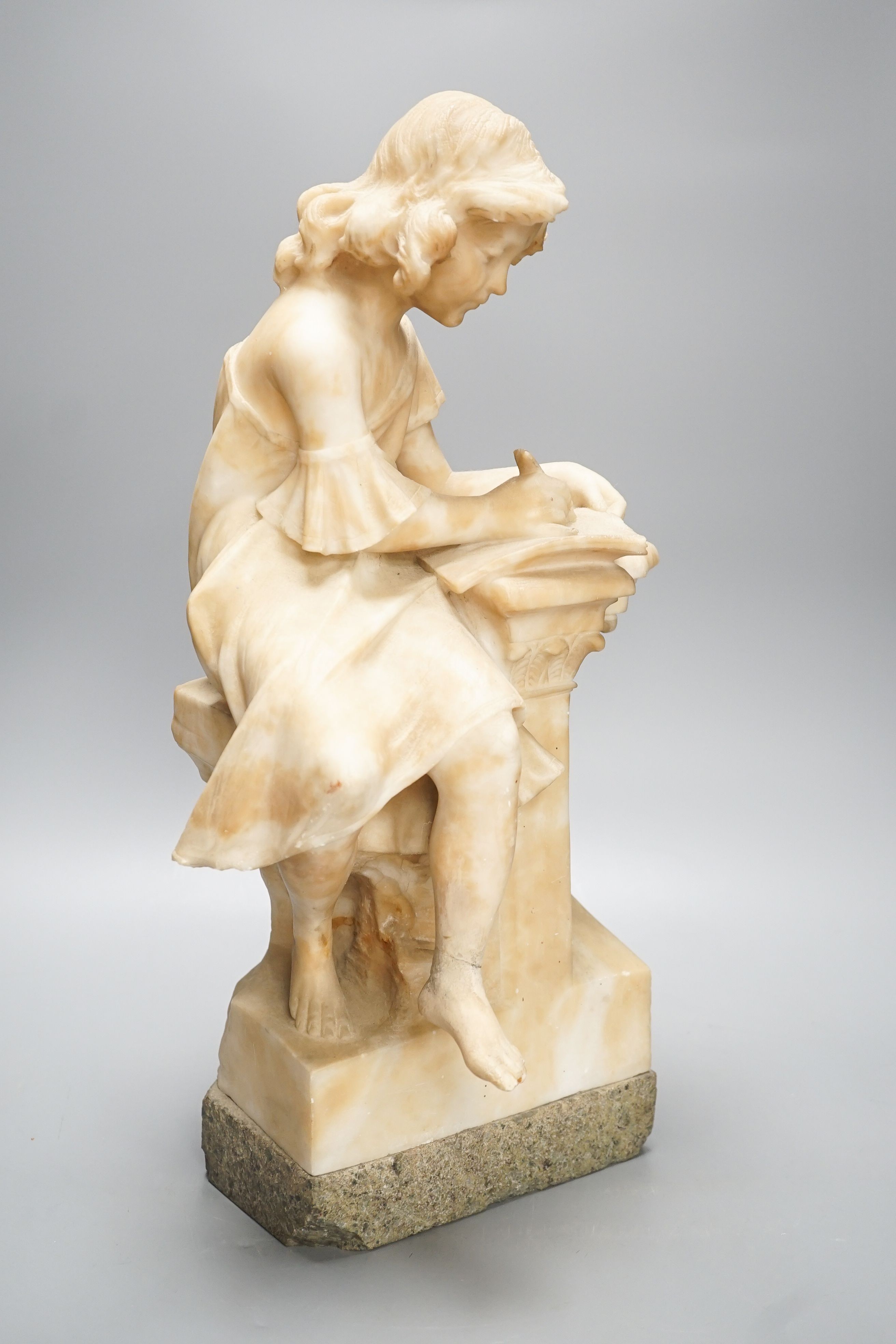 A late 19th century Italian carved alabaster figure of a girl seated, writing at a pillar 47cm